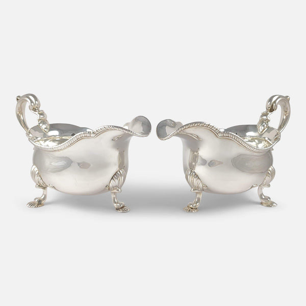 the pair of antique sterling silver sauce boats viewed angled towards each other