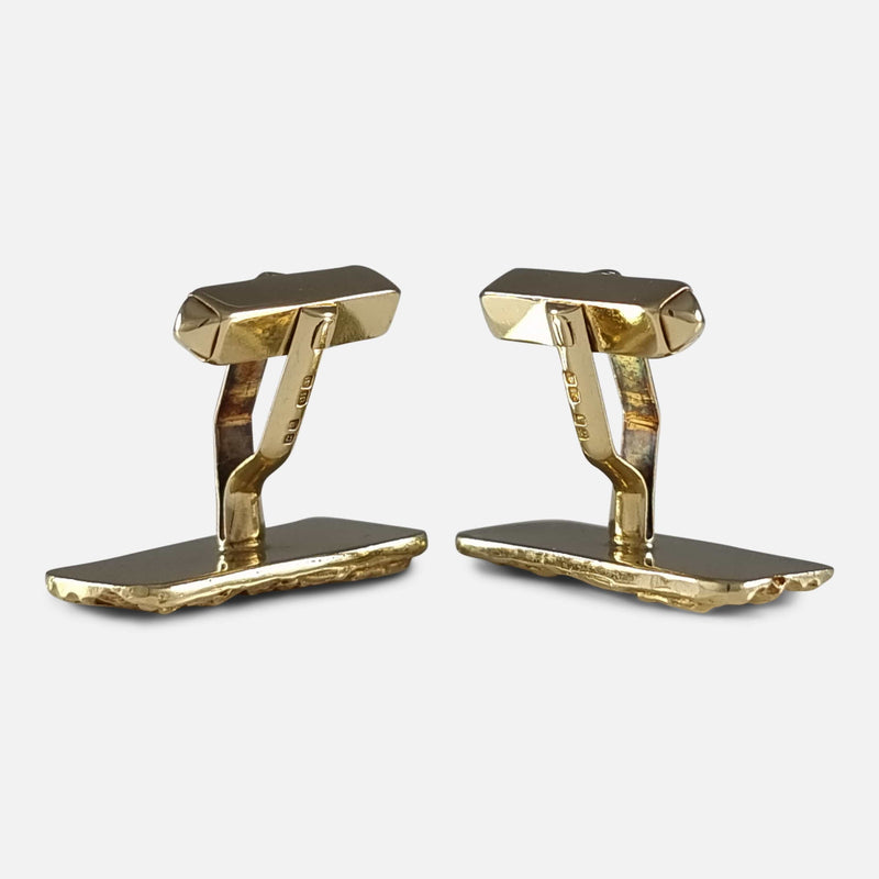 Cufflinks stand vertically, face down, with T-bar connectors pointing upwards.