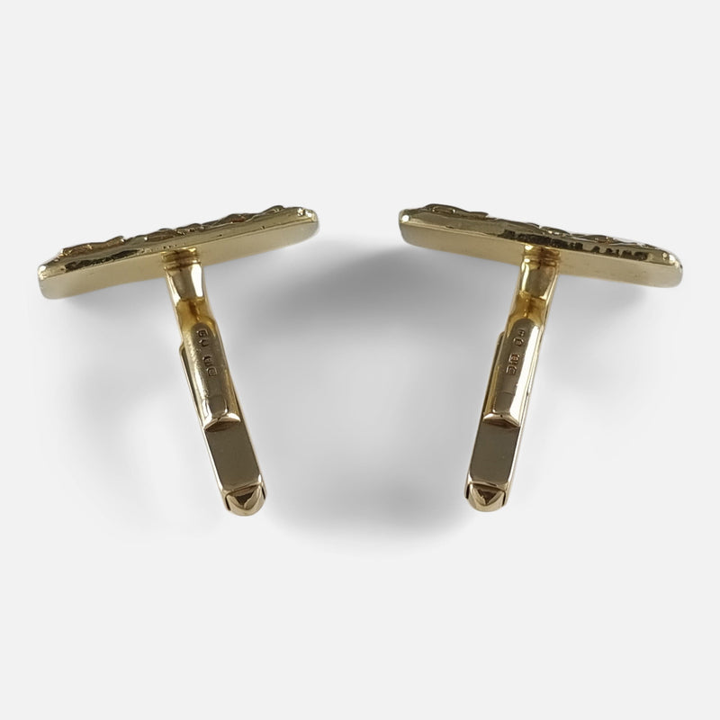 From a bird's-eye view, cufflinks are seen with their backs facing away, T-bar connectors turned to an unlocked/open position, emphasizing their functionality.