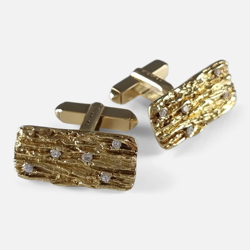 Photo captured from an elevated angle, showing one cufflink in front of the other, slightly angled away to highlight their design.
