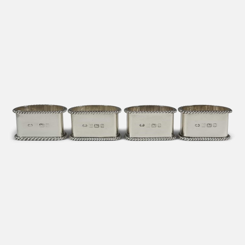 the napkin rings viewed in a row from the back with hallmarks to the forefront