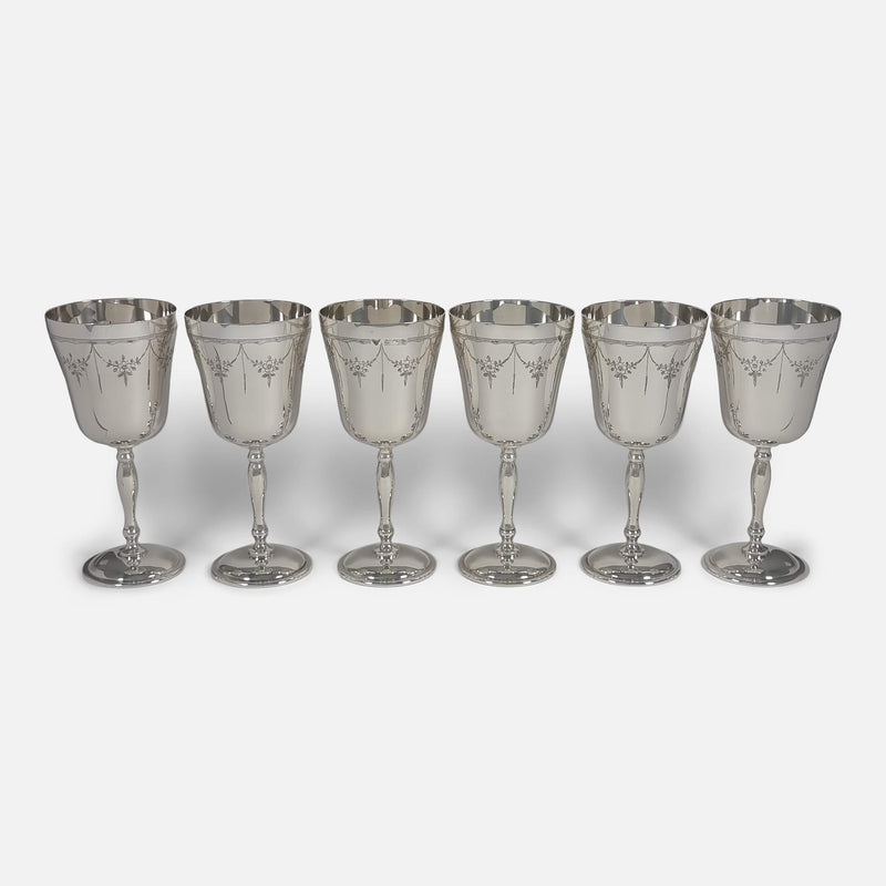 Eye-level view of six goblets aligned side by side, presenting their design and uniformity at close range.