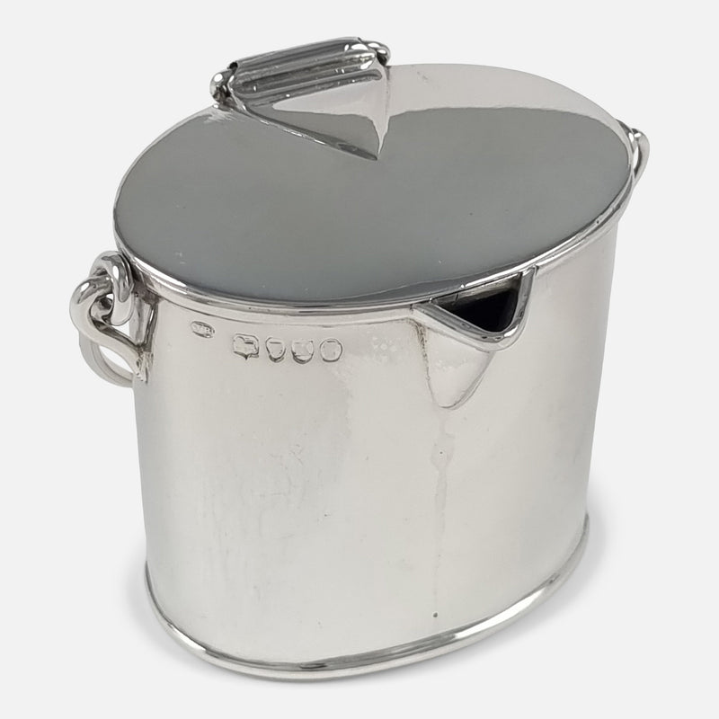 birds eye view with cream pail at an angle with spout to forefront facing slightly towards the right
