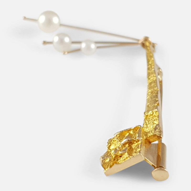 the gold brooch viewed from the right side on