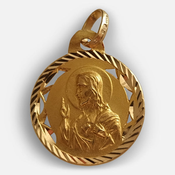 a depiction of the sacred heart of Jesus to one side of the pendant