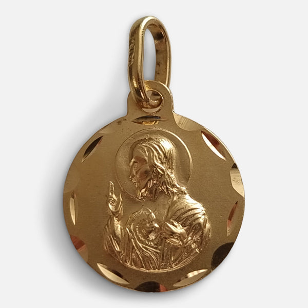 a depiction of the sacred heart of Jesus to one side of the pendant