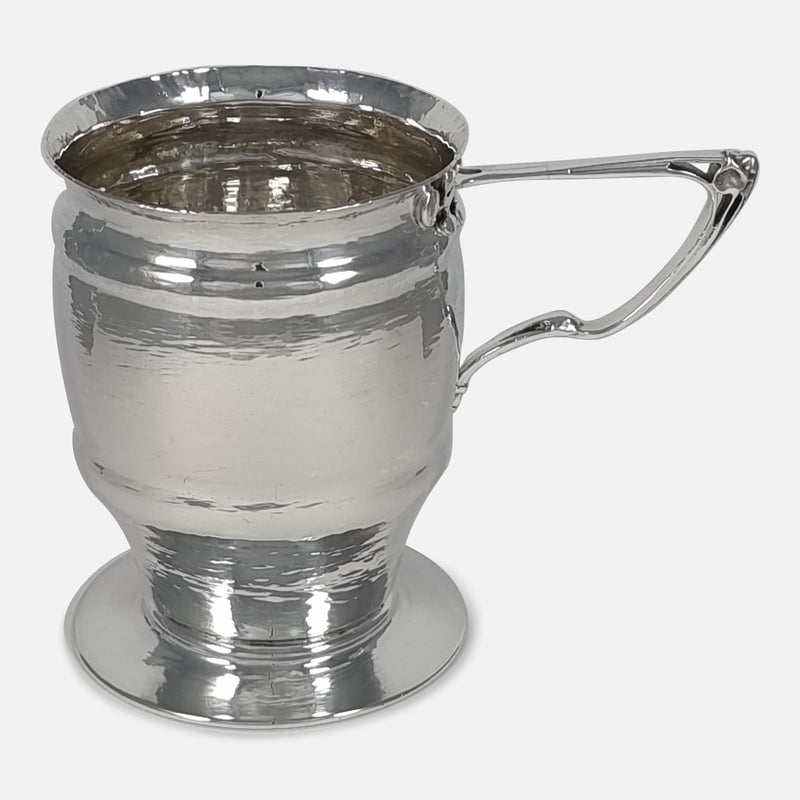 the silver mug viewed from a slightly raised position with handle pointing to the right side