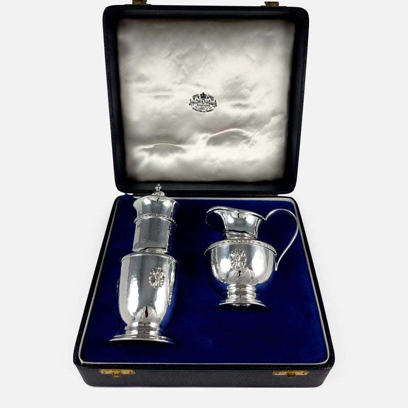 the Arts and Crafts style sterling silver sugar caster and cream jug viewed in their presentation case