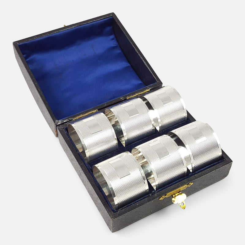 the sterling silver engine turned napkin rings in their case viewed diagonally