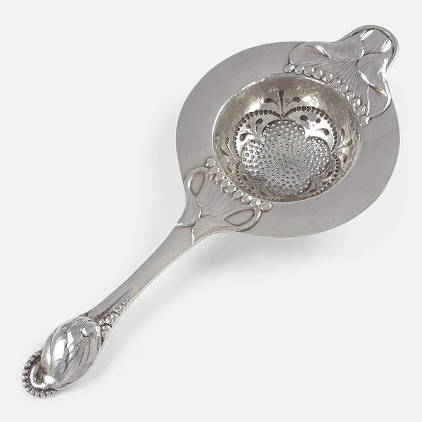 the silver tea strainer by Evald Nielsen viewed diagonally