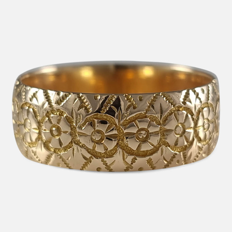 the gold ring in focus to include the engraved decoration