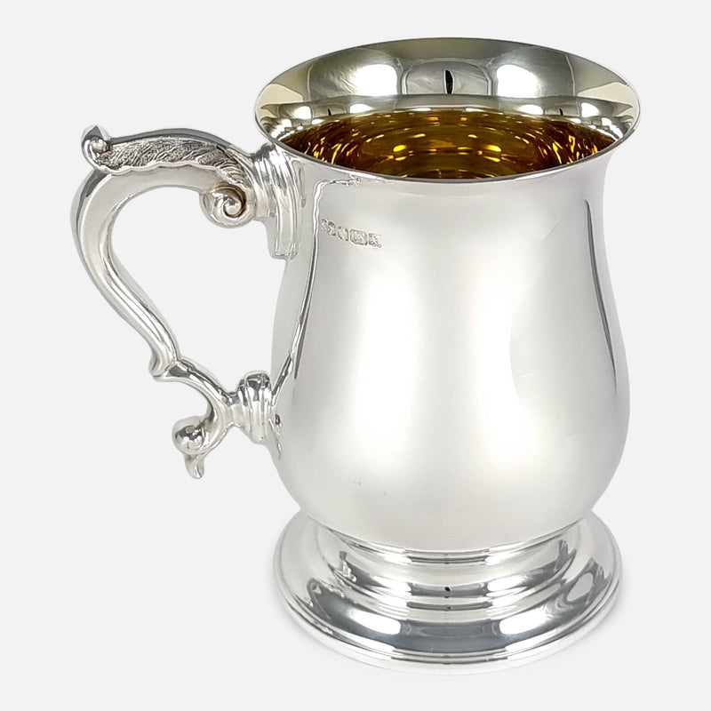 a side on view of the silver mug with handle pointing to the left side