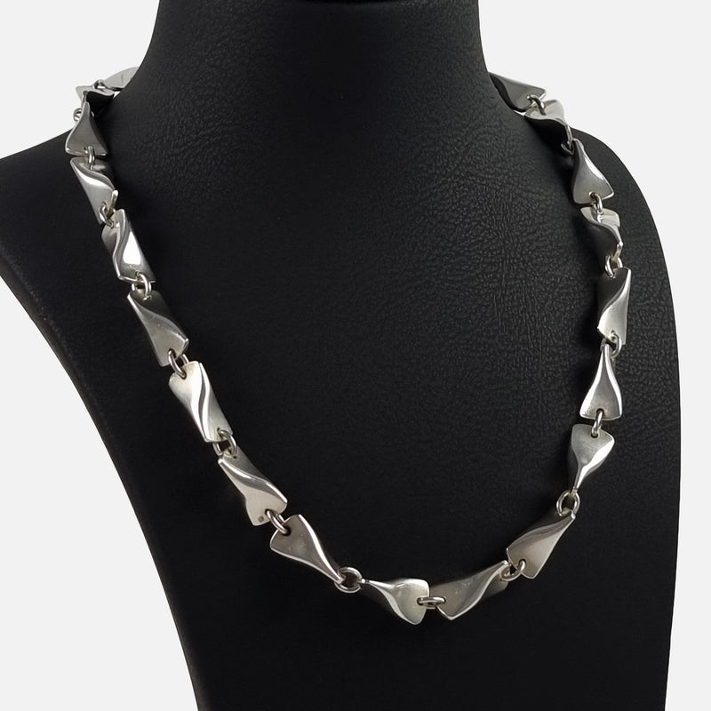 the necklace designed by Edvard Kindt-Larsen for Georg Jensen, viewed on a display stand