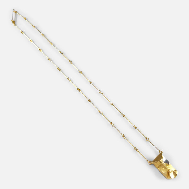 the gold pendant necklace extended diagonally