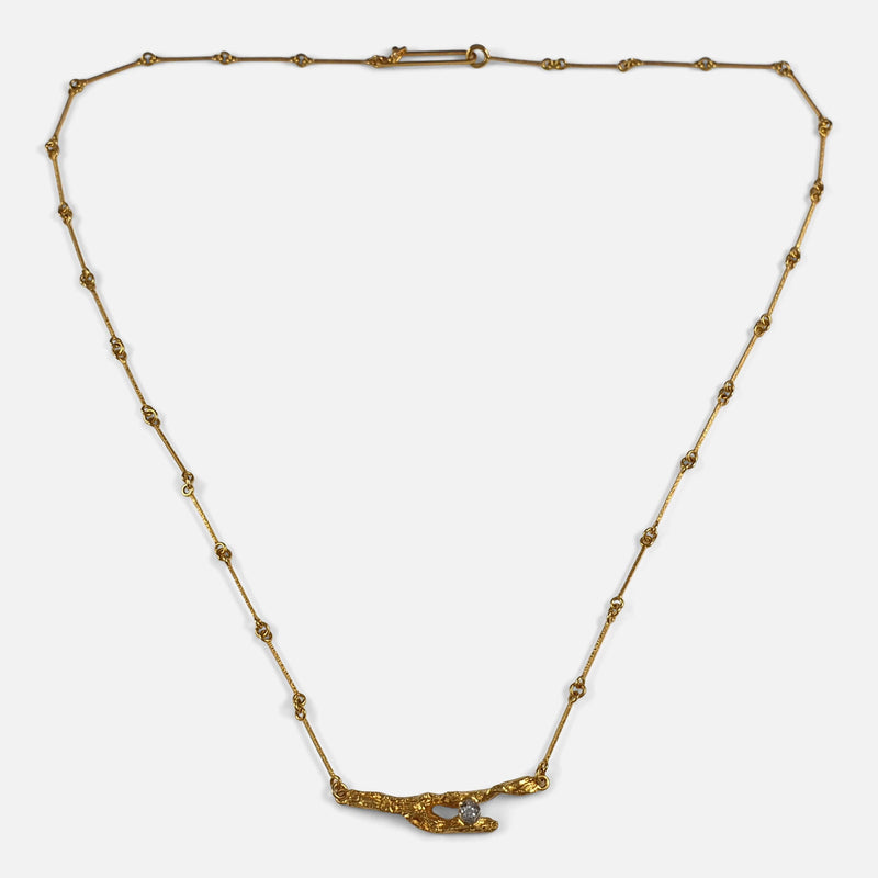 a view of the gold and diamond necklace viewed from the front