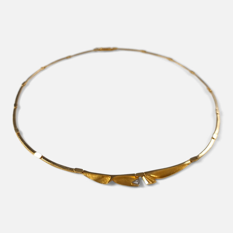 a view of the gold necklace with diamond to the forefront