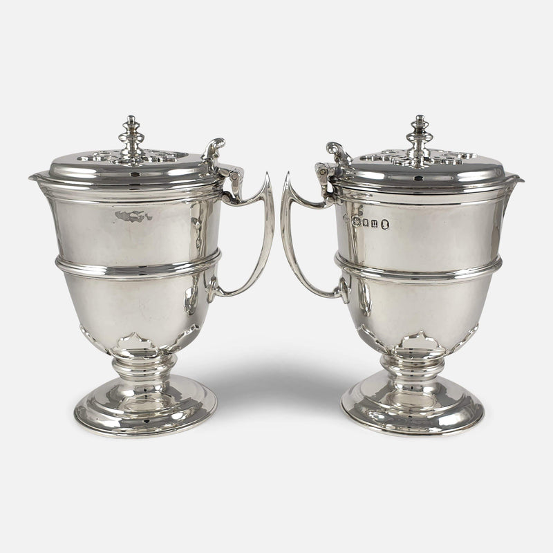 The pair of sterling silver ewers facing in opposite directions