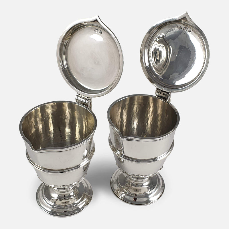the pair of silver jugs viewed with lids raised