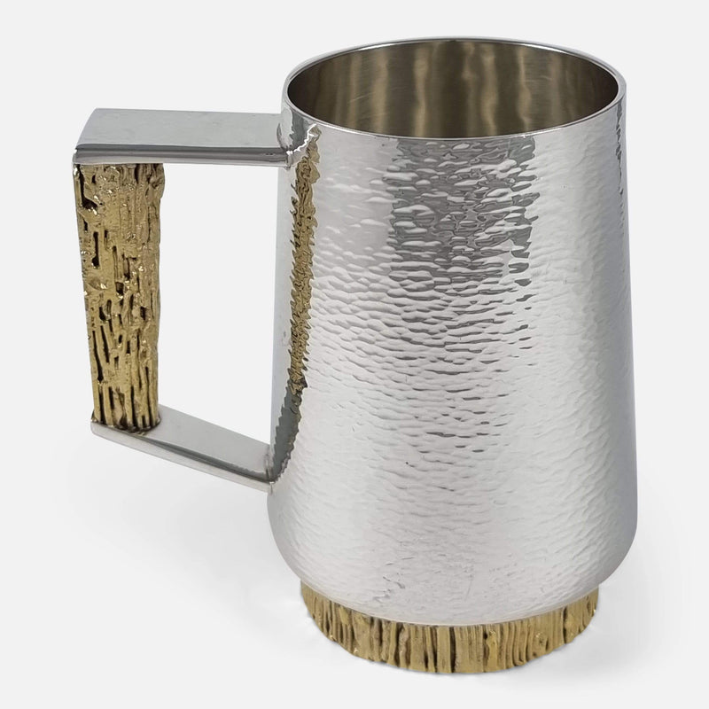 the sterling silver gilt mug by stuart devlin facing side on with handle towards the left
