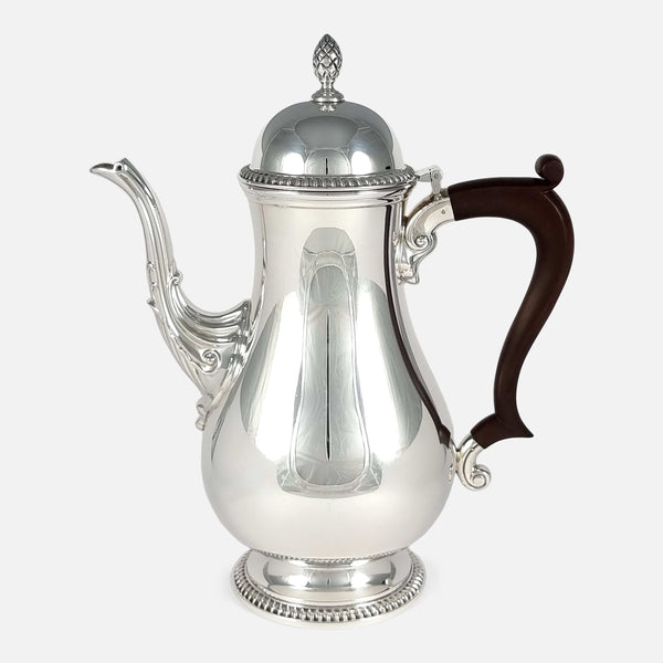 the sterling silver coffee pot viewed side on with handle facing towards the right