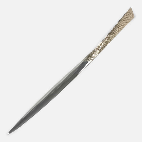 the letter opener viewed diagonally with tip to the forefront and pointing left