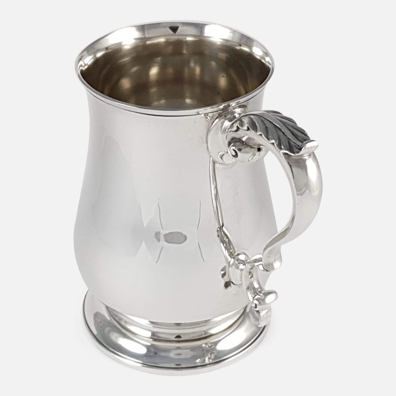 the silver tankard with handle to forefront