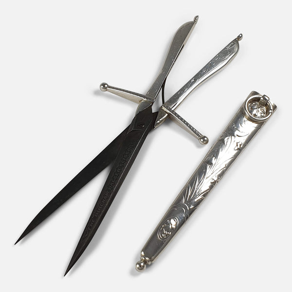 the Victorian silver scissors with metal blades lying next to the silver scabbard