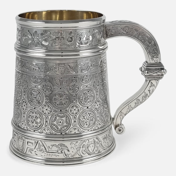 the Victorian sterling silver engraved mug viewed side on with handle facing towards the right