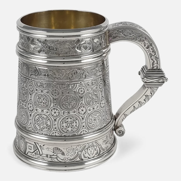 the Victorian sterling silver engraved mug viewed side on with handle facing towards the right